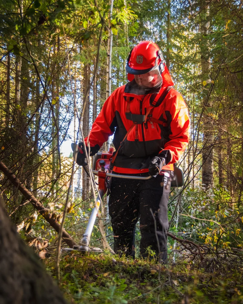 Opérateur en équipement de protection, débroussailleuse en main, photo d'illustration